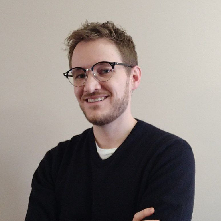 Incredibly handsome man wears glasses and poses handomsly.